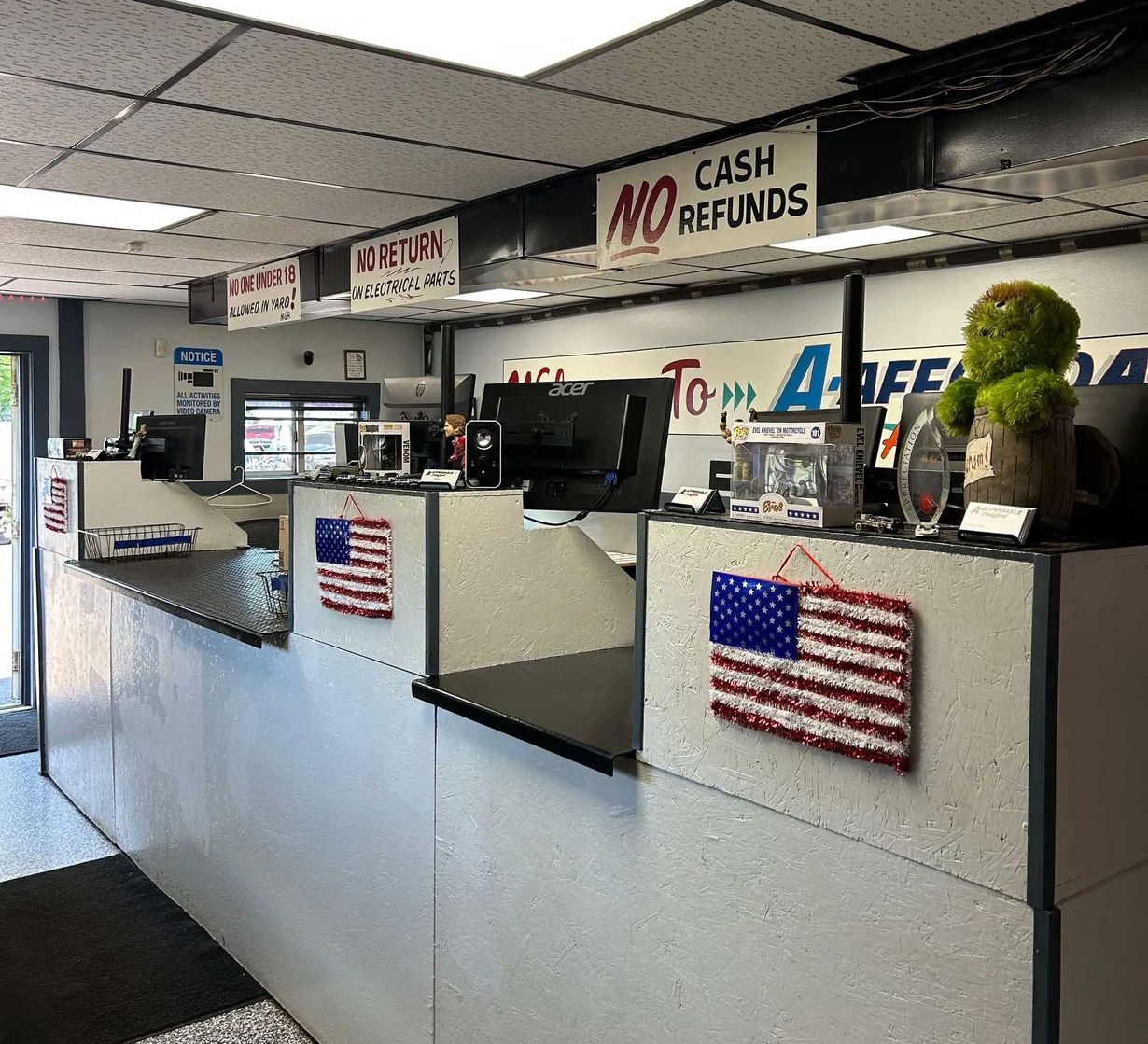 Interior of a store with counters, computers, American flags, and a sign that says, 