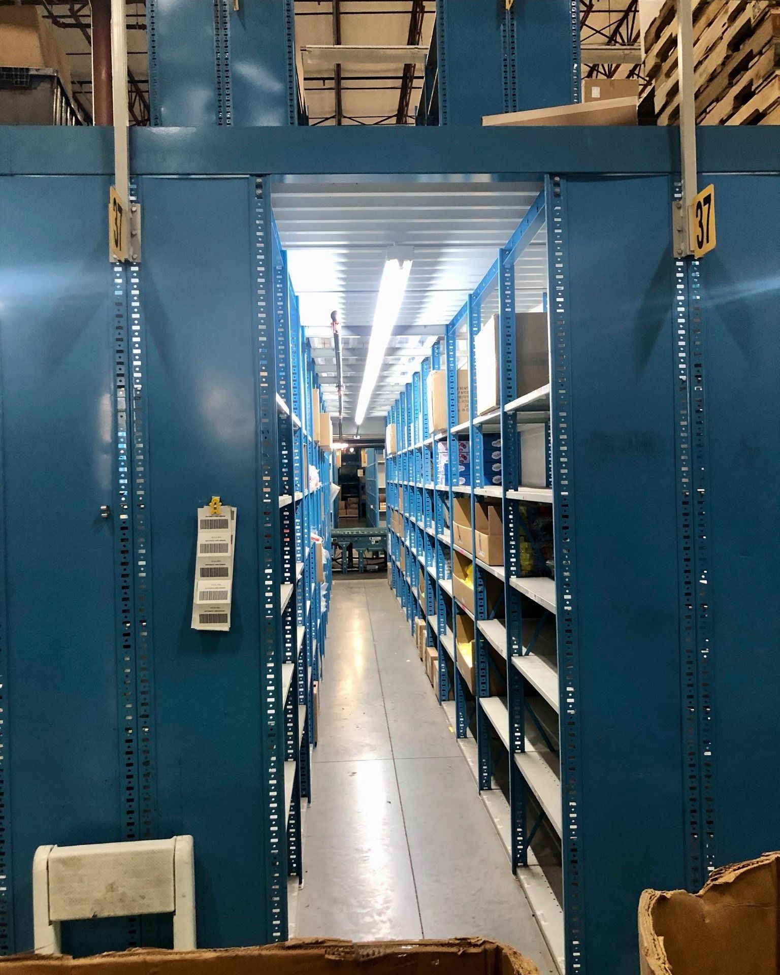 A warehouse with lots of shelves and boxes on the floor