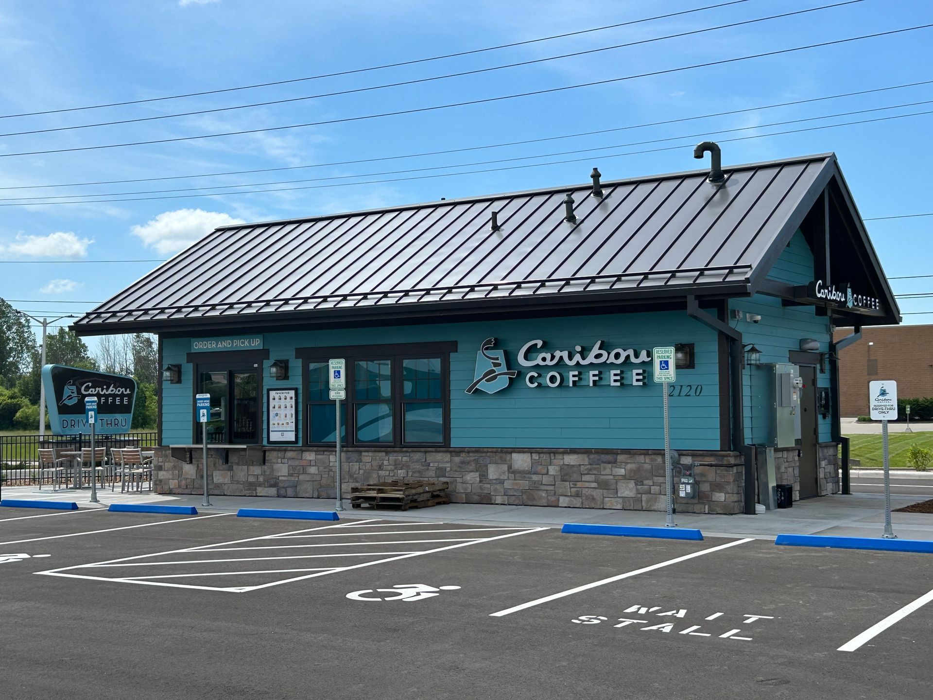 A caribou coffee store with a parking lot in front of it