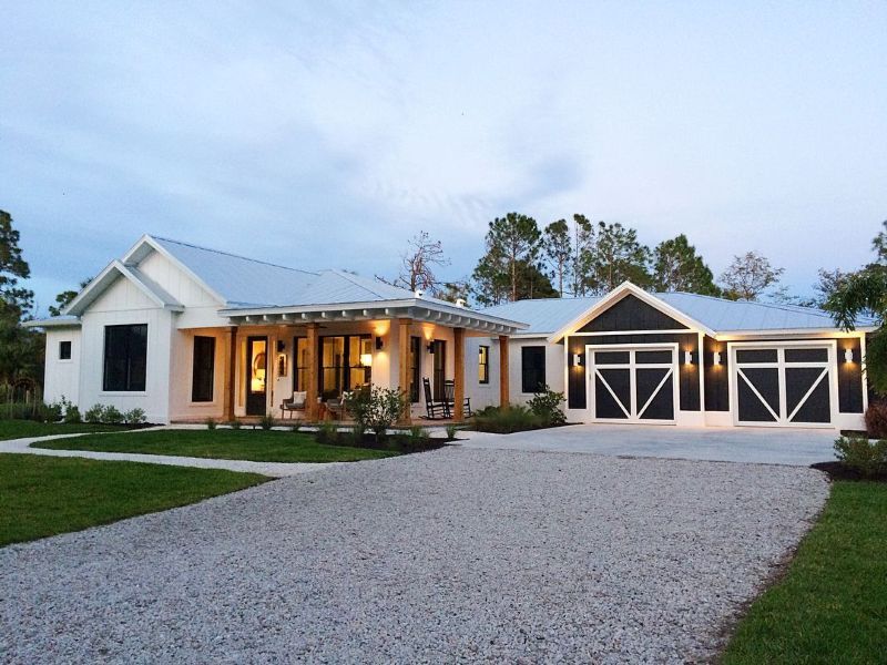 A large white house with a black garage door