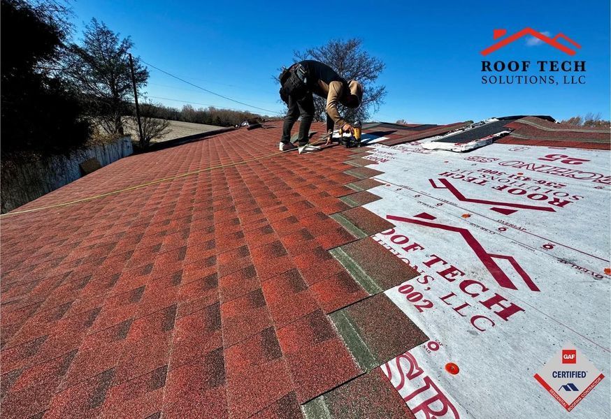 Roofer installing red shingles on a roof. Blue sky in the background, company logo in the corner.