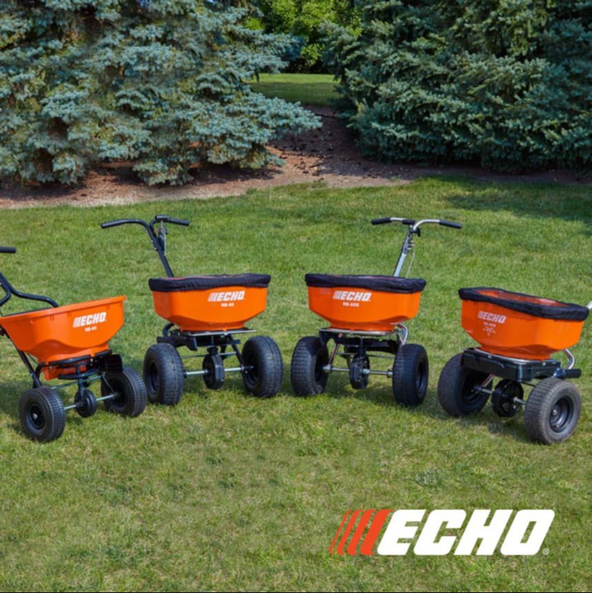 Three echo spreaders are lined up on the grass