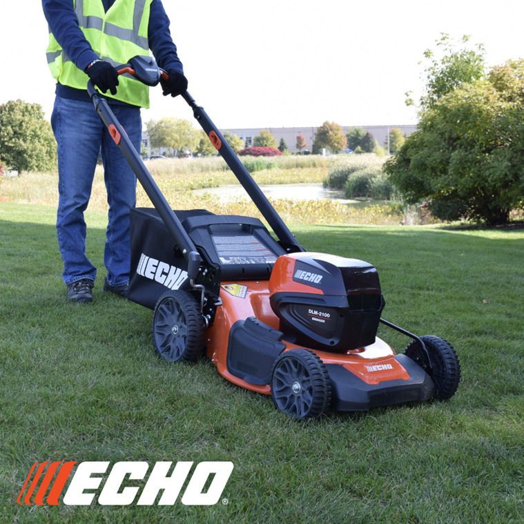 A man is using an echo lawn mower on a lush green lawn