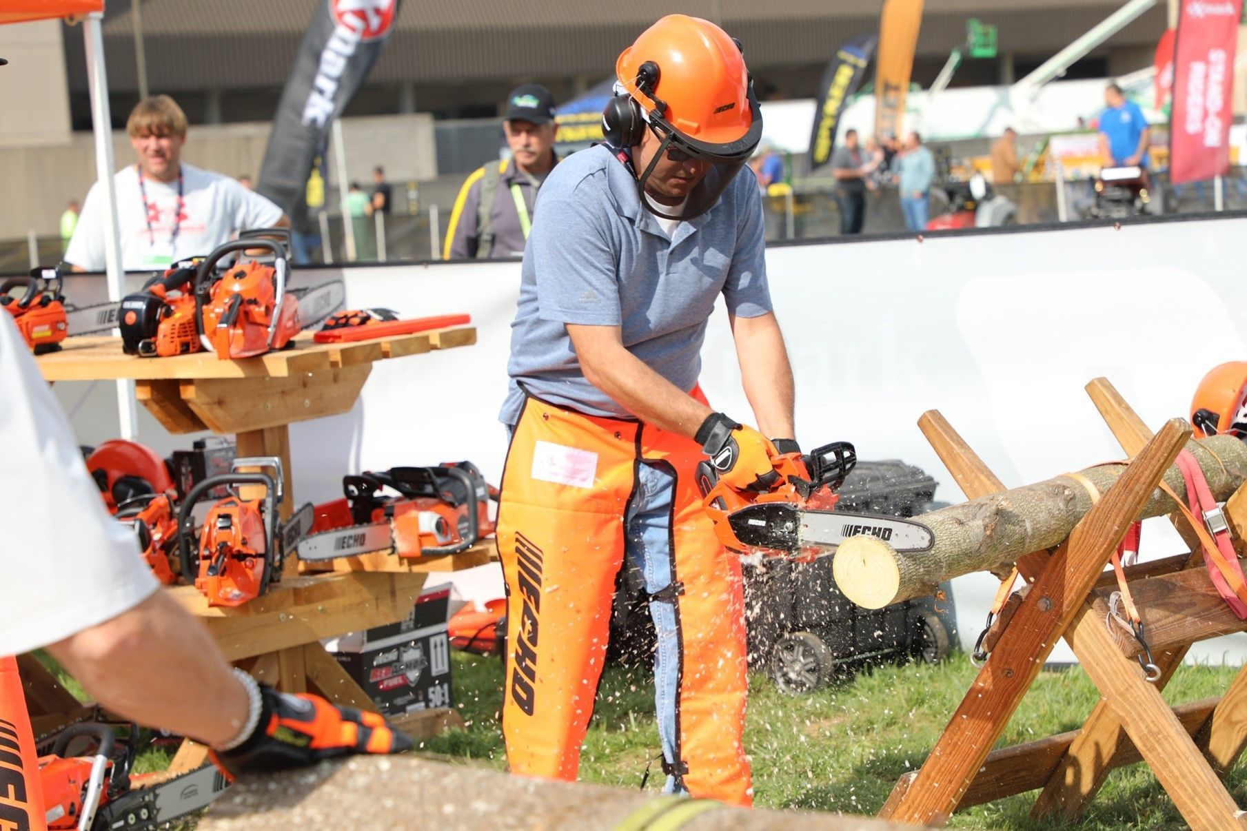 A man is cutting a tree branch with a chainsaw.