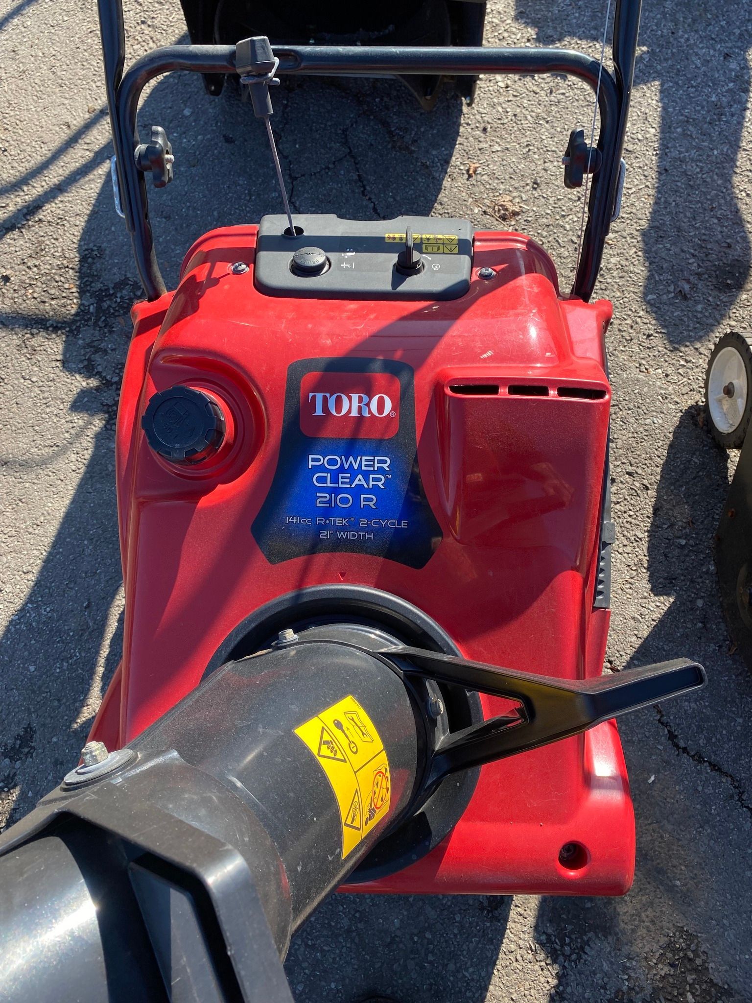 A red toro snow blower is sitting on the ground.
