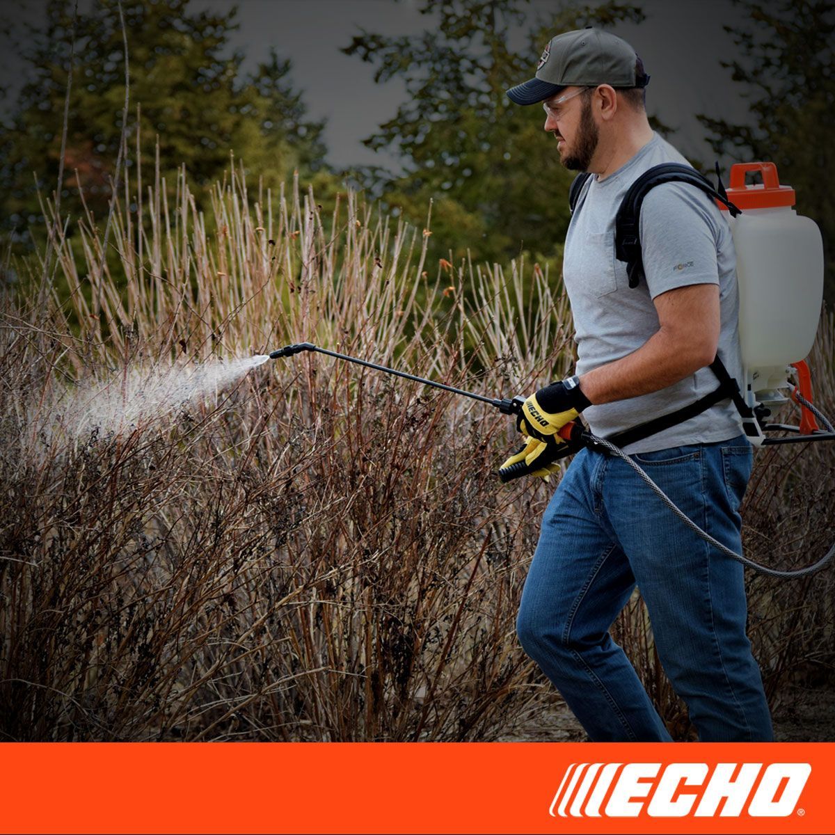 A man is spraying a bush with a backpack sprayer.