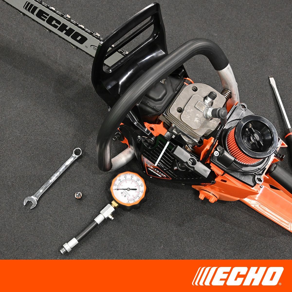 A chainsaw with a wrench and a pressure gauge next to it