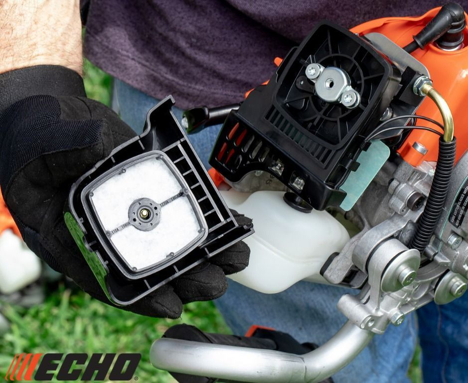 A person is holding a echo brush cutter in their hand