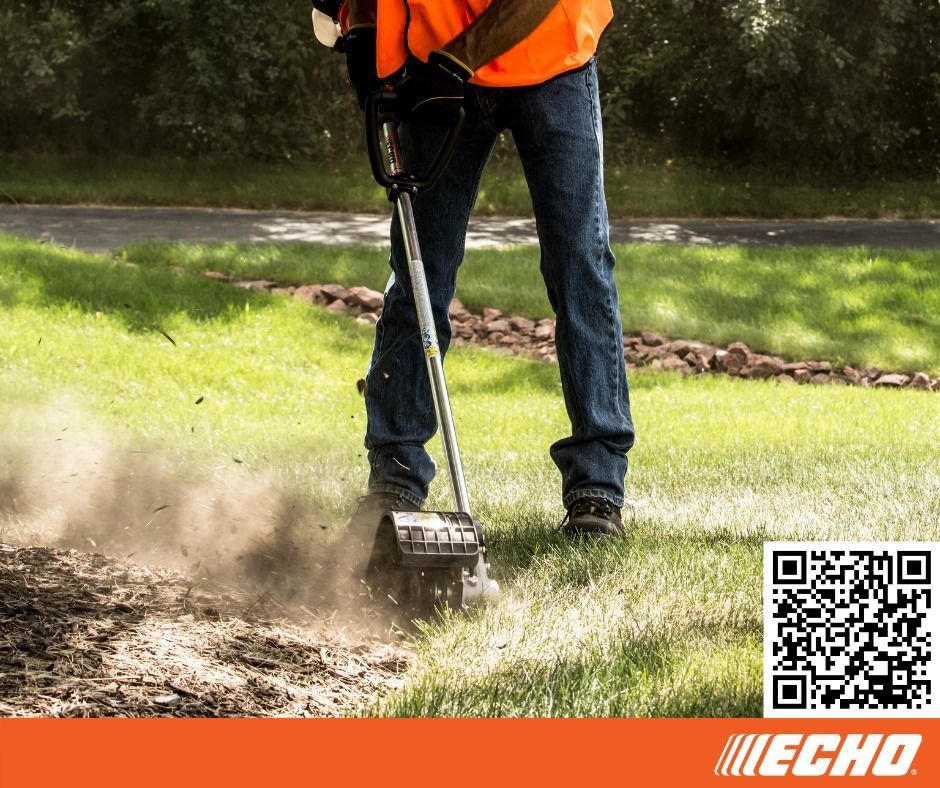 A man is using a echo lawn mower on a lush green lawn.