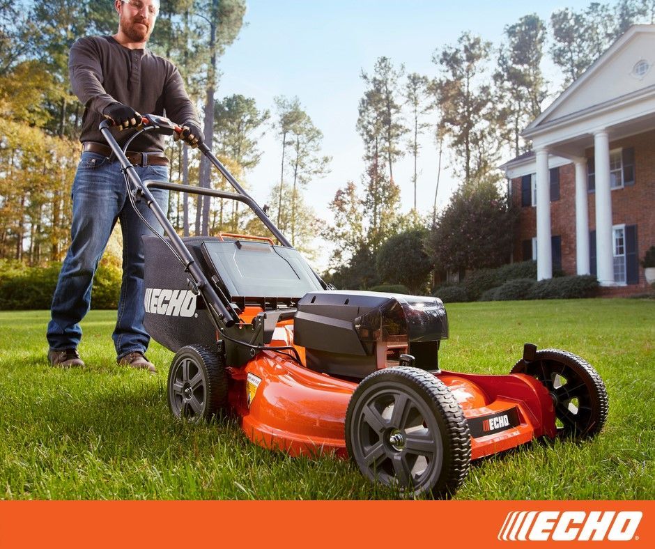 A man is pushing a echo lawn mower on a lush green lawn