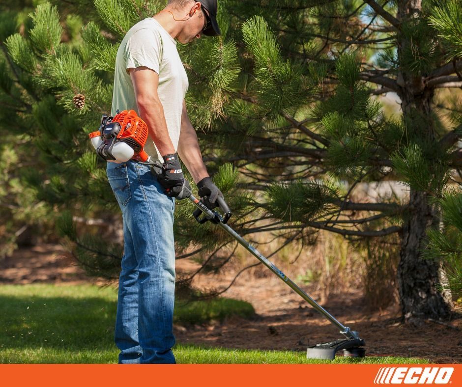 A man is cutting grass with a echo trimmer.