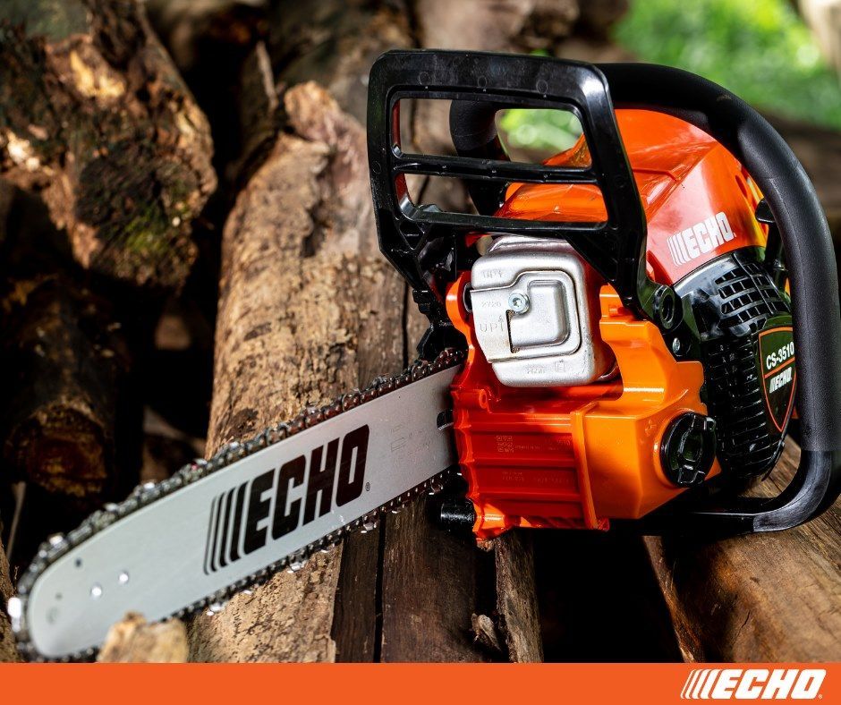 A chainsaw is sitting on top of a pile of logs.