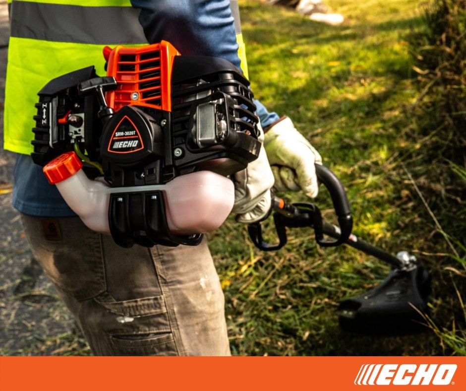 A person is using a echo trimmer to cut grass.
