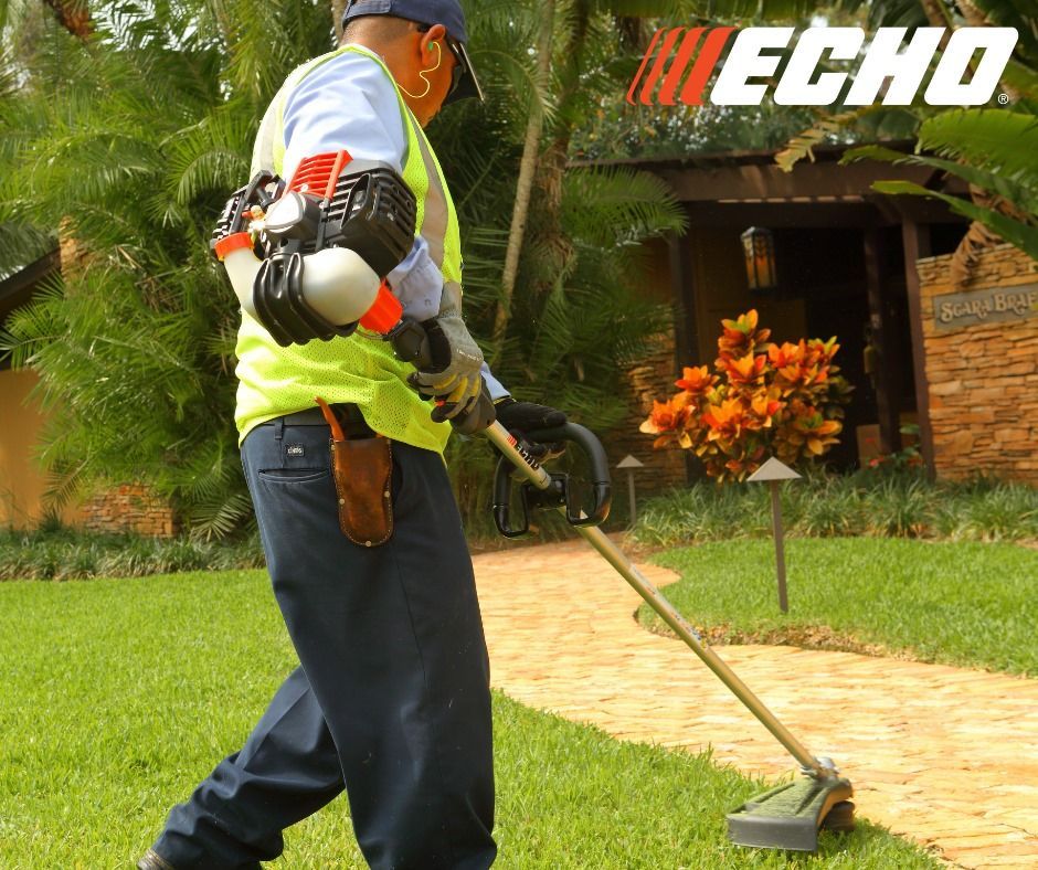 A man is using a echo lawn mower to cut the grass