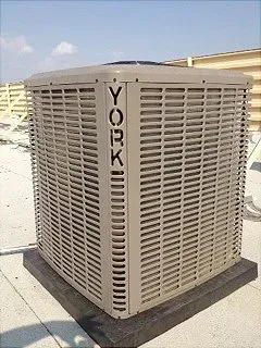 York air conditioner unit on a rooftop, tan and gray, with the word 
