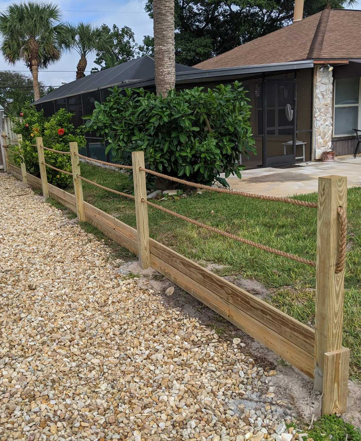 a wooden fence with ropes is in front of a house .
