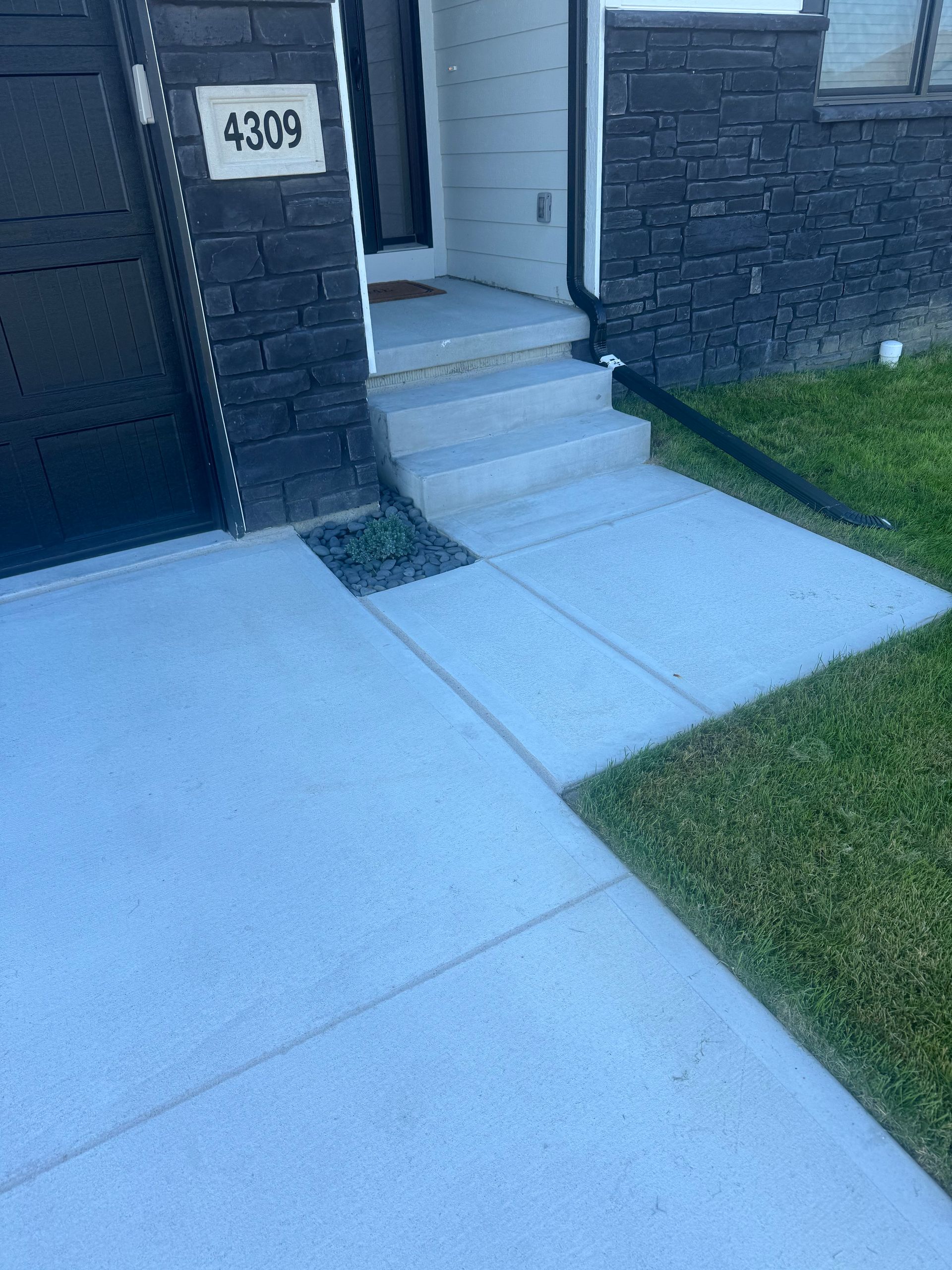 Concrete walkway and steps leading to a house with address 