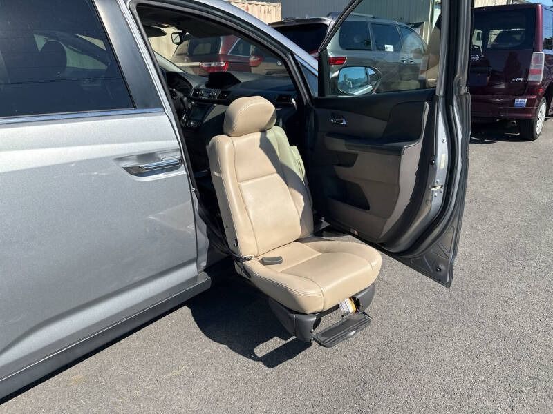 Gray SUV with lowered, tan-colored accessible passenger seat extended out.