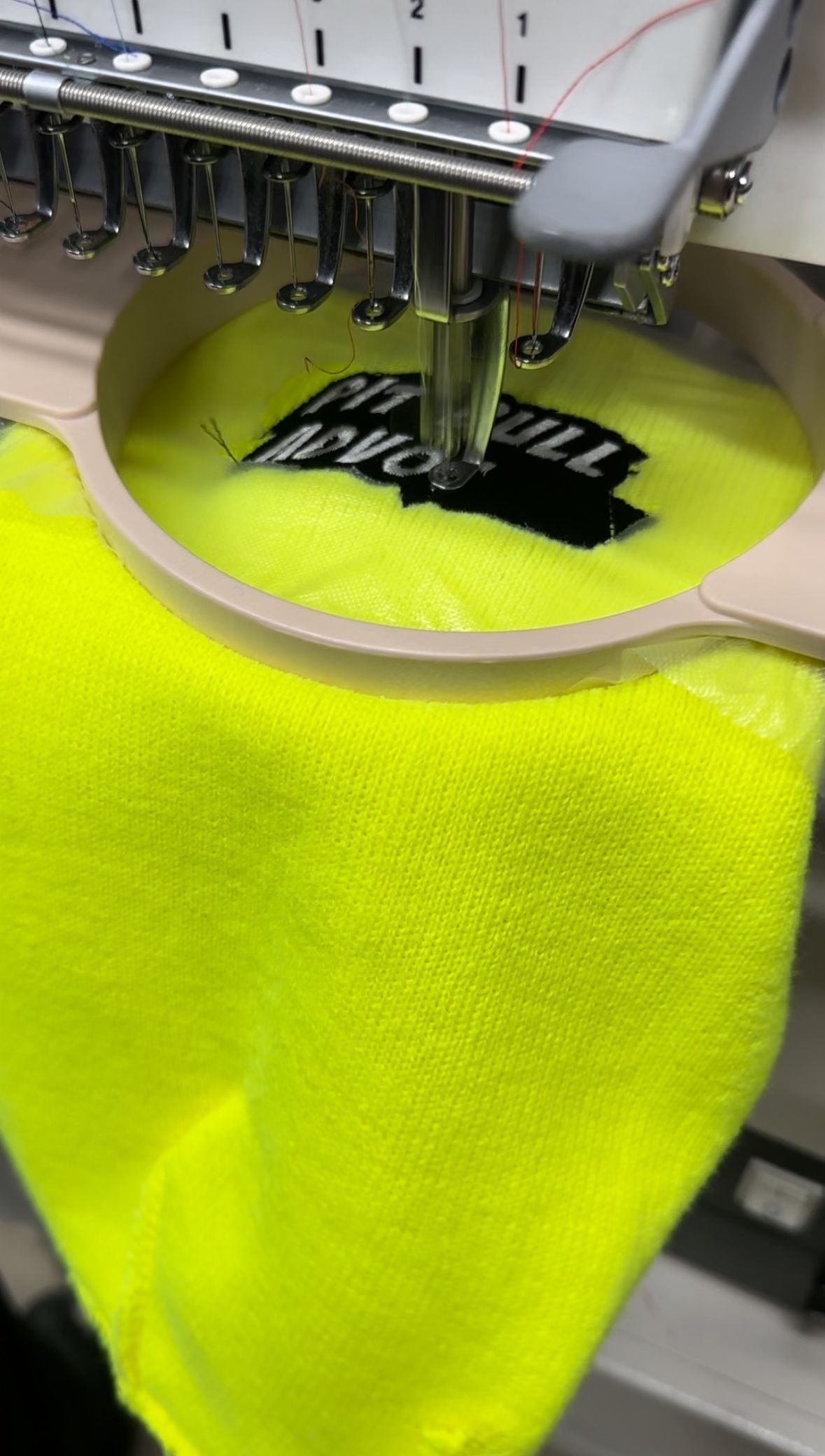 a yellow shirt is being embroidered on a machine