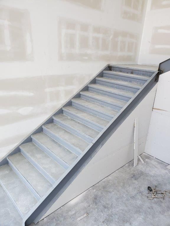 A set of stairs in a room with a concrete floor