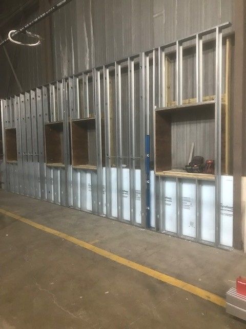 A warehouse with a lot of metal frames and shelves