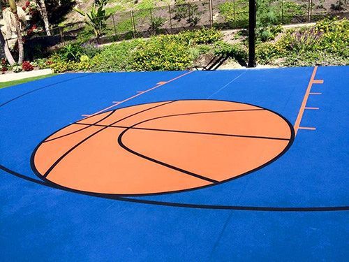 A blue and orange basketball court with a basketball in the middle