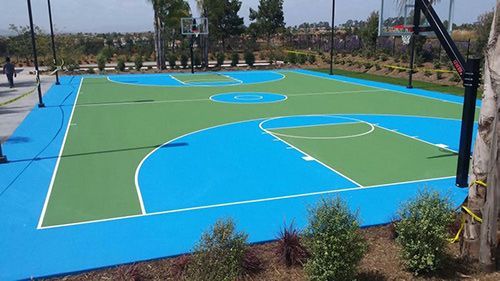 A blue and green basketball court with a basketball hoop