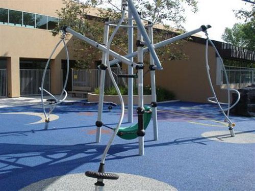 A playground with a green swing in the middle