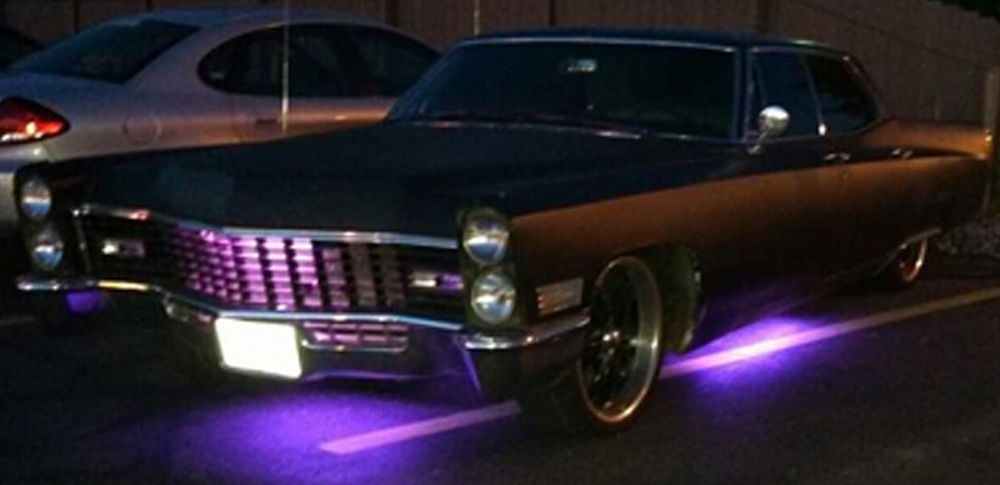 A black car with purple lights on the bottom of it