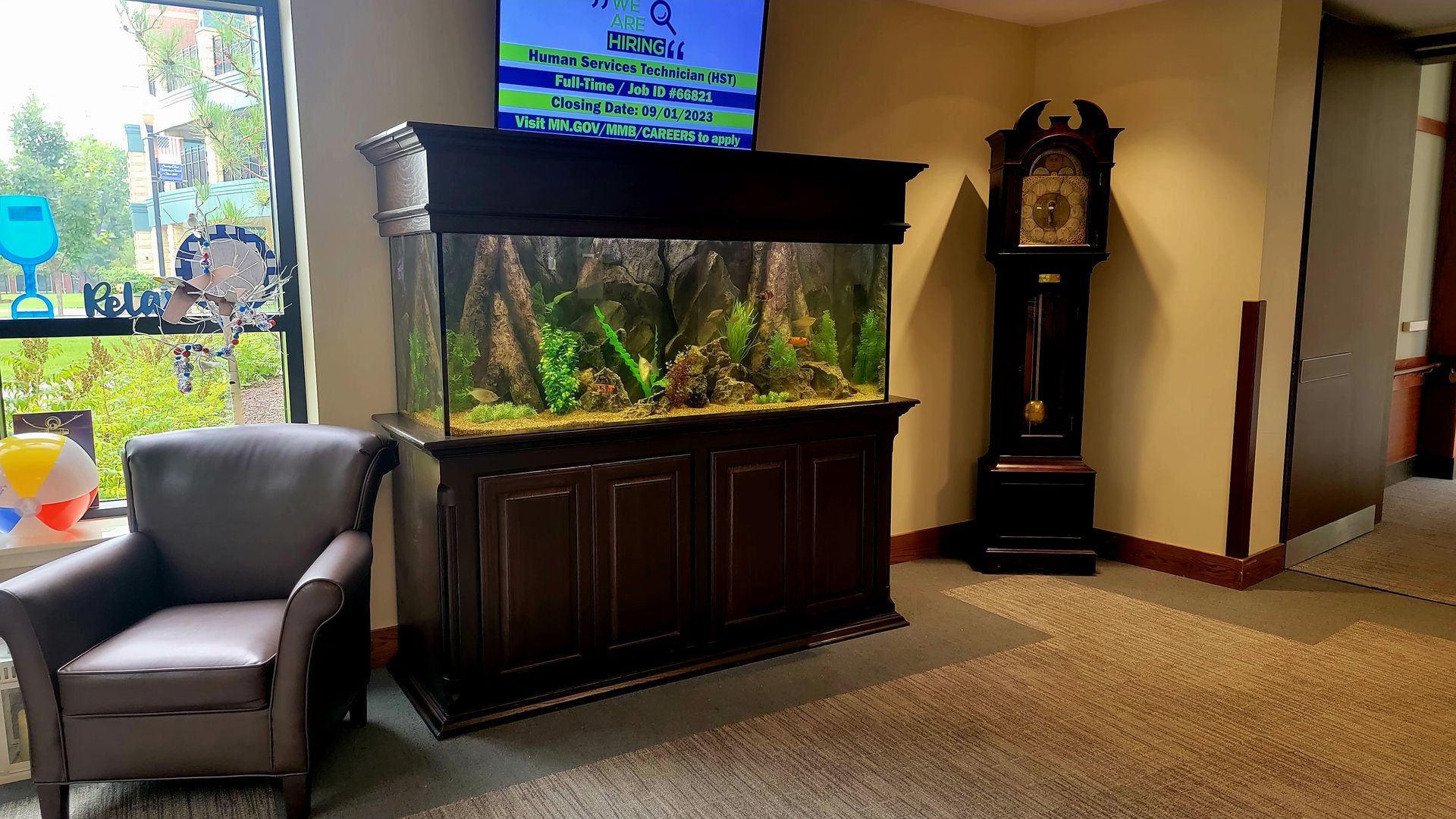 A living room with a large aquarium and a clock