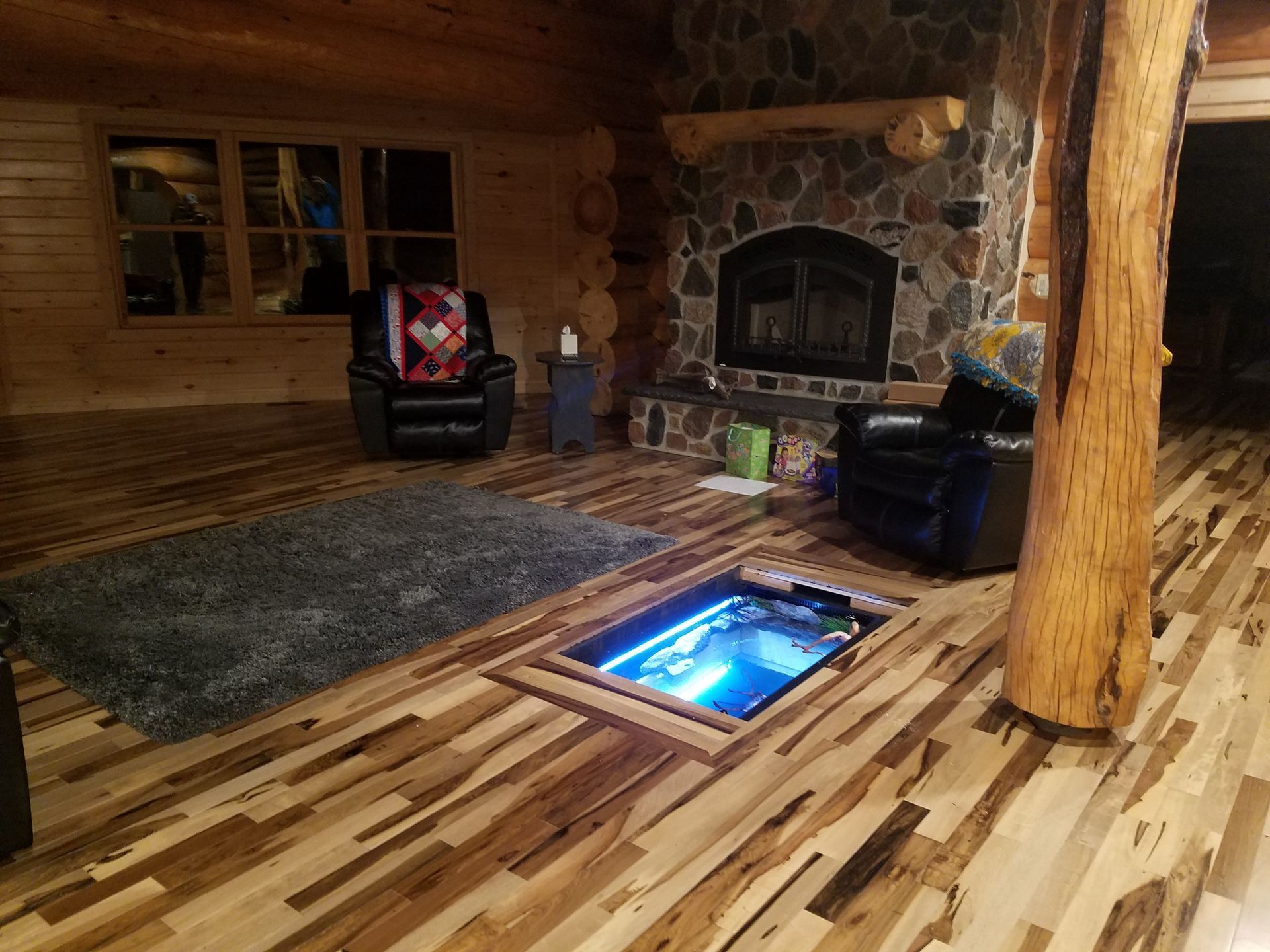 A living room with a fireplace and a wooden floor