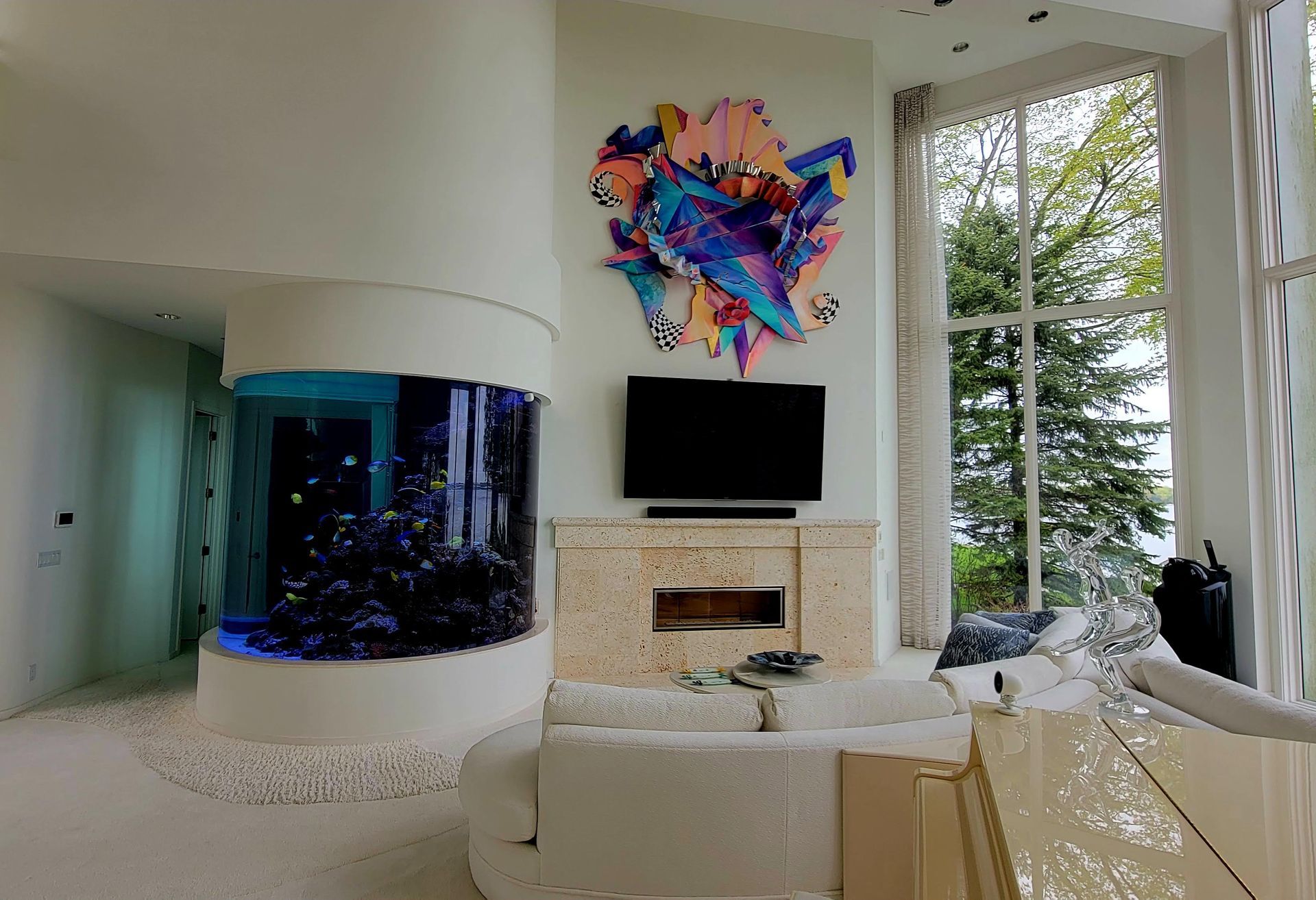 A living room with a large aquarium and a flat screen tv.