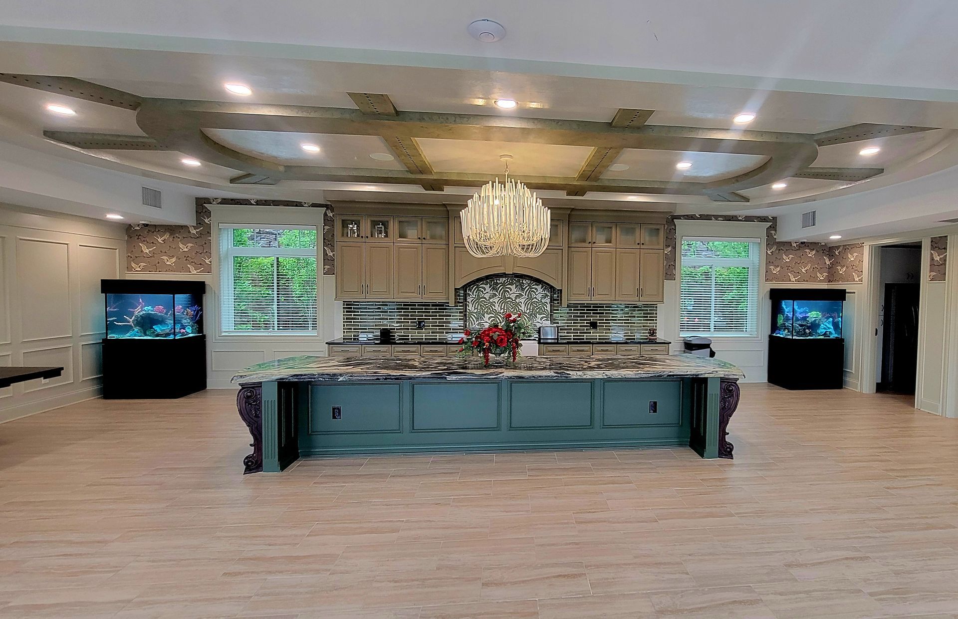 A large kitchen with a large island and a chandelier hanging from the ceiling.