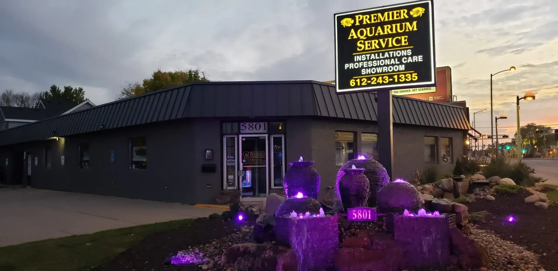 A building with a sign that says aquarium next to a fountain.