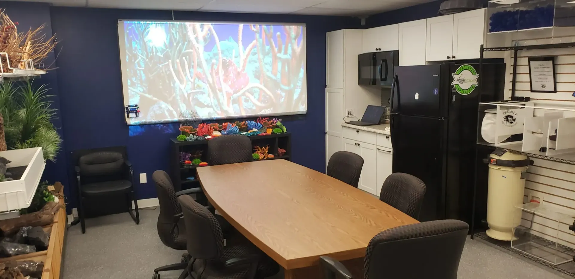 A conference room with a long table and chairs and a projector screen.