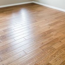 A close-up of a wooden floor in an empty room.