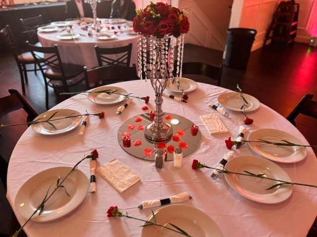 a table with plates and a vase of flowers on it