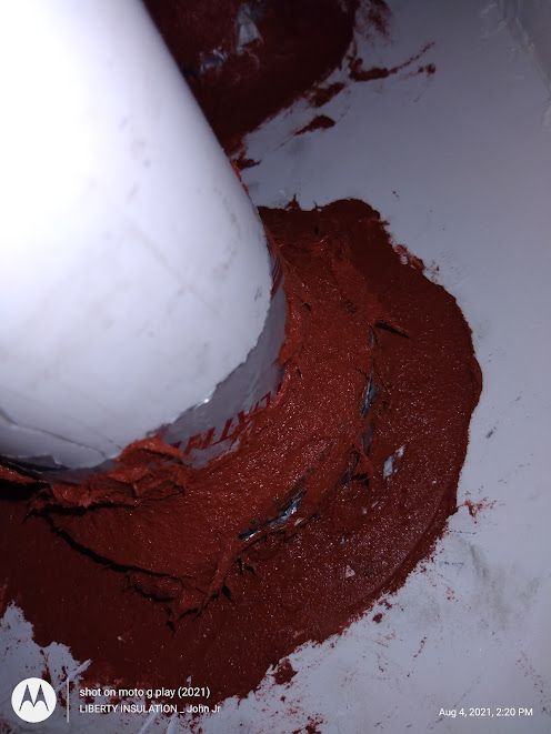 A white pipe is surrounded by red paint on a white surface