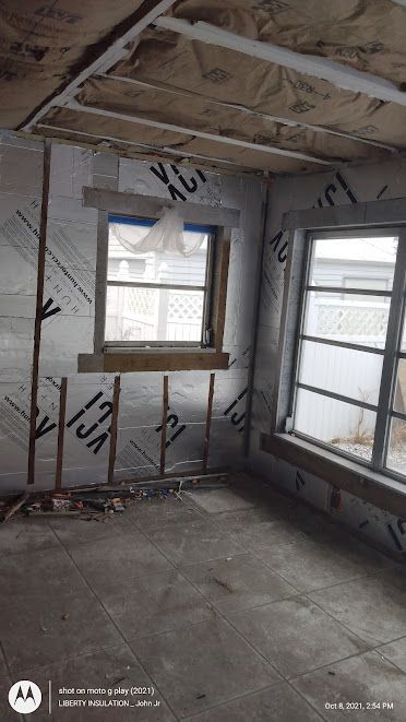 A room with a lot of windows and insulation on the walls.