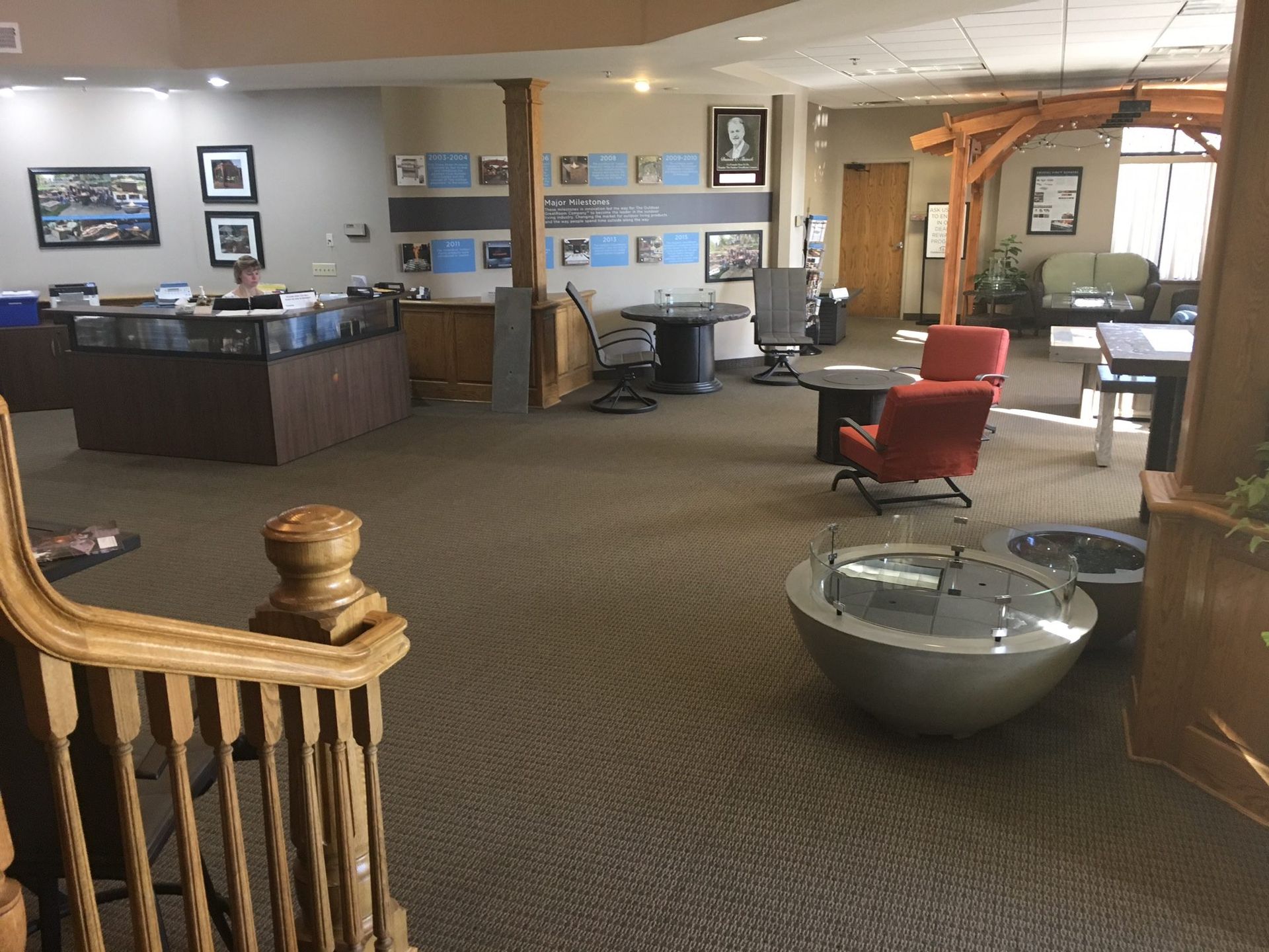 Lobby seating area with red chairs, reception desk, and framed wall art.