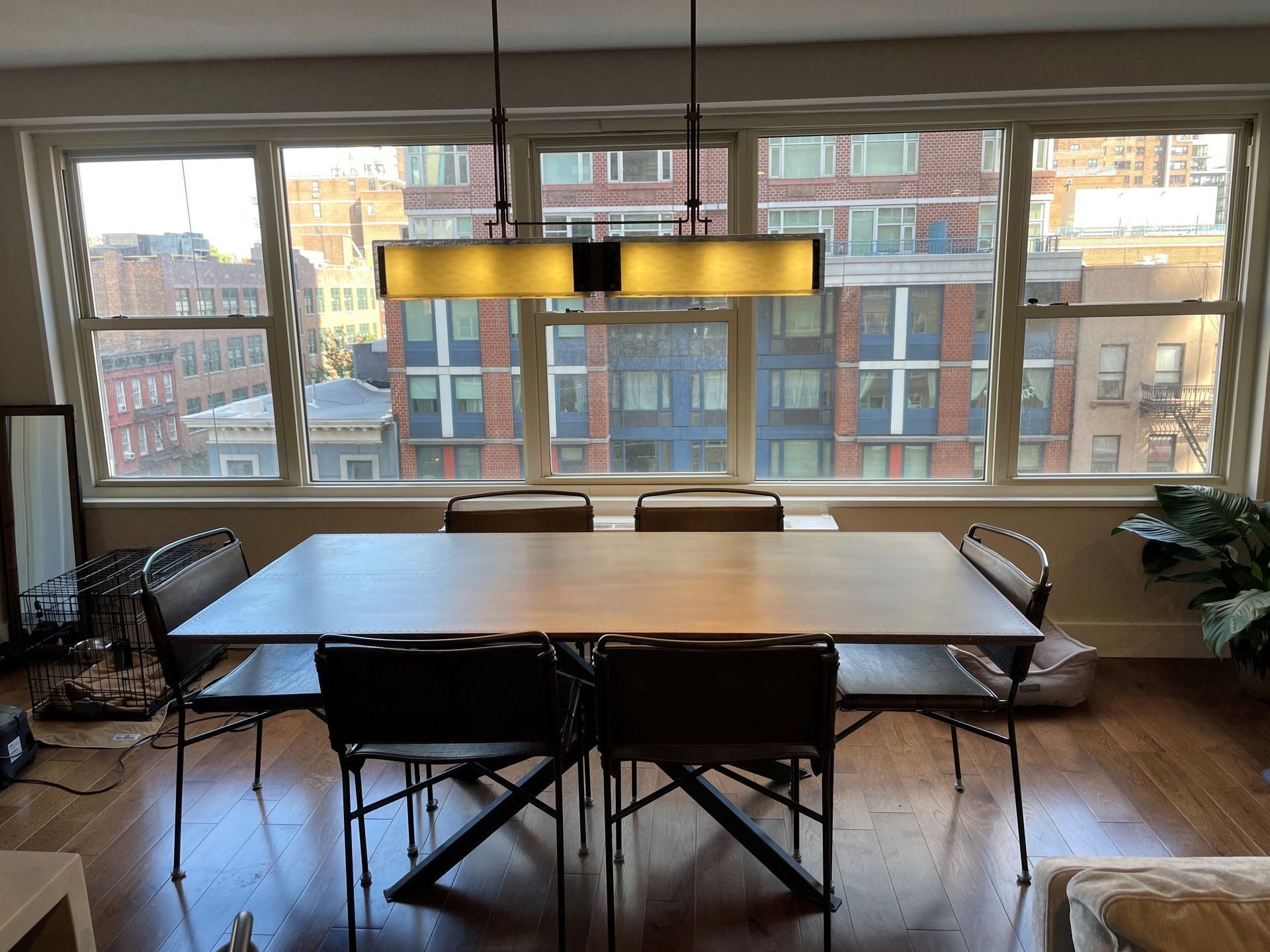 Dining room with table and chairs in front of large windows with city view.