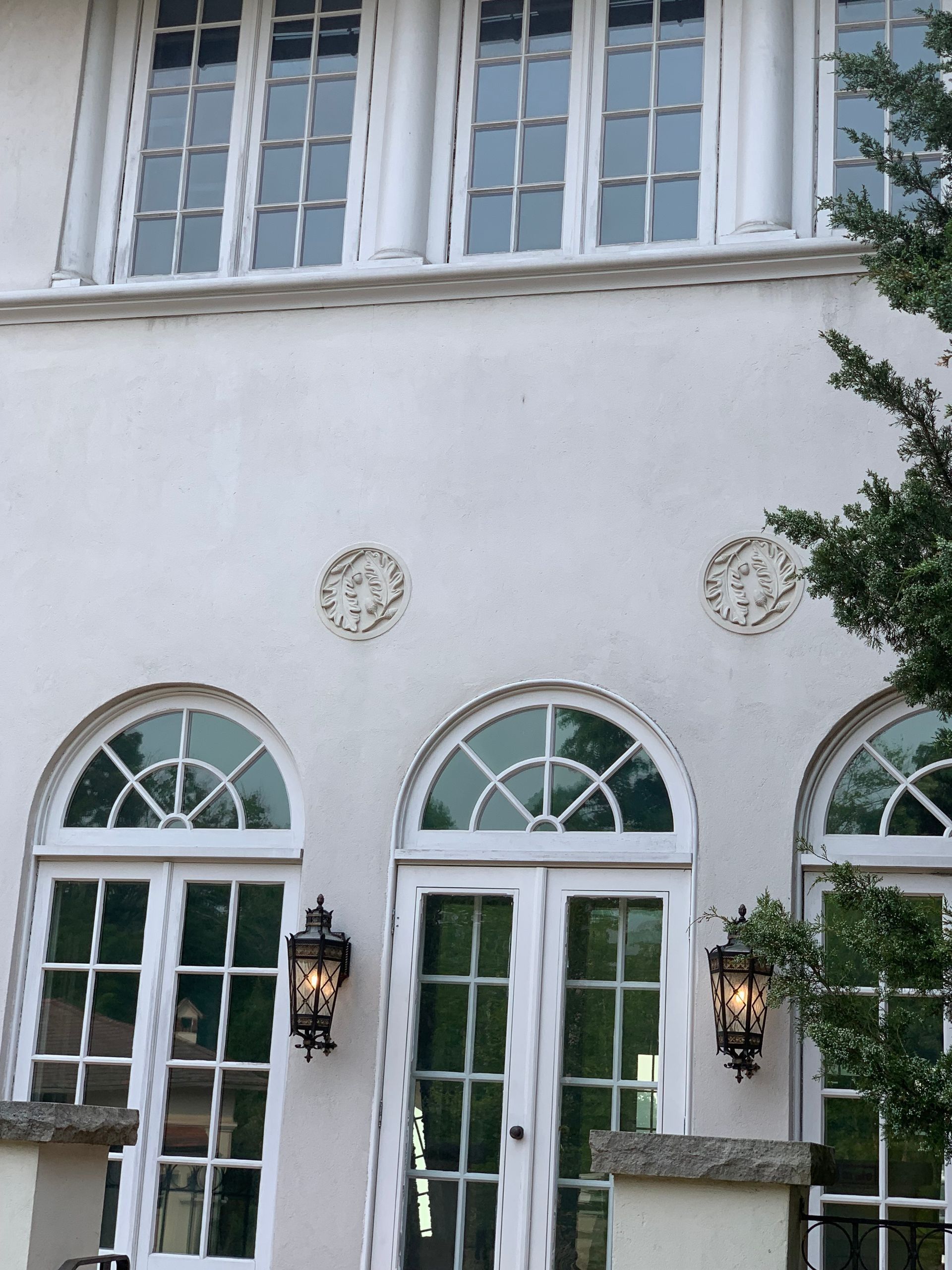 White building with arched windows and upper rectangular windows.