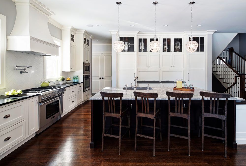 A kitchen with white cabinets and black counter tops