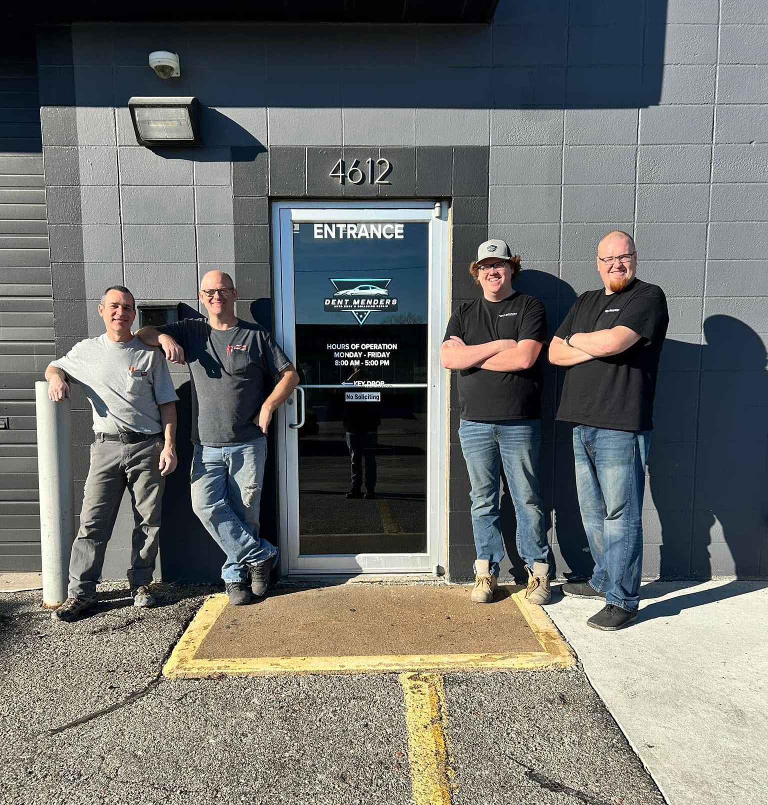 A group of men are standing in front of a building.