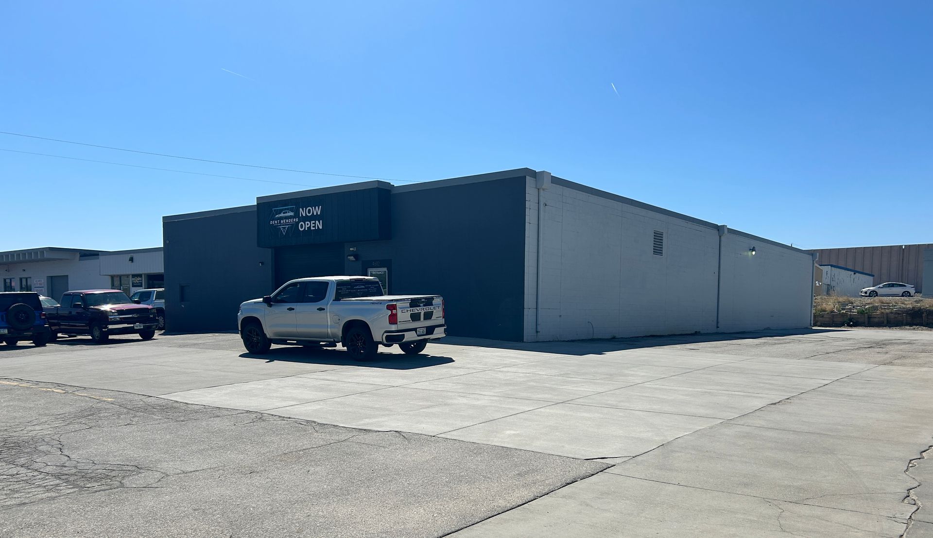 A white truck is parked in front of a building.