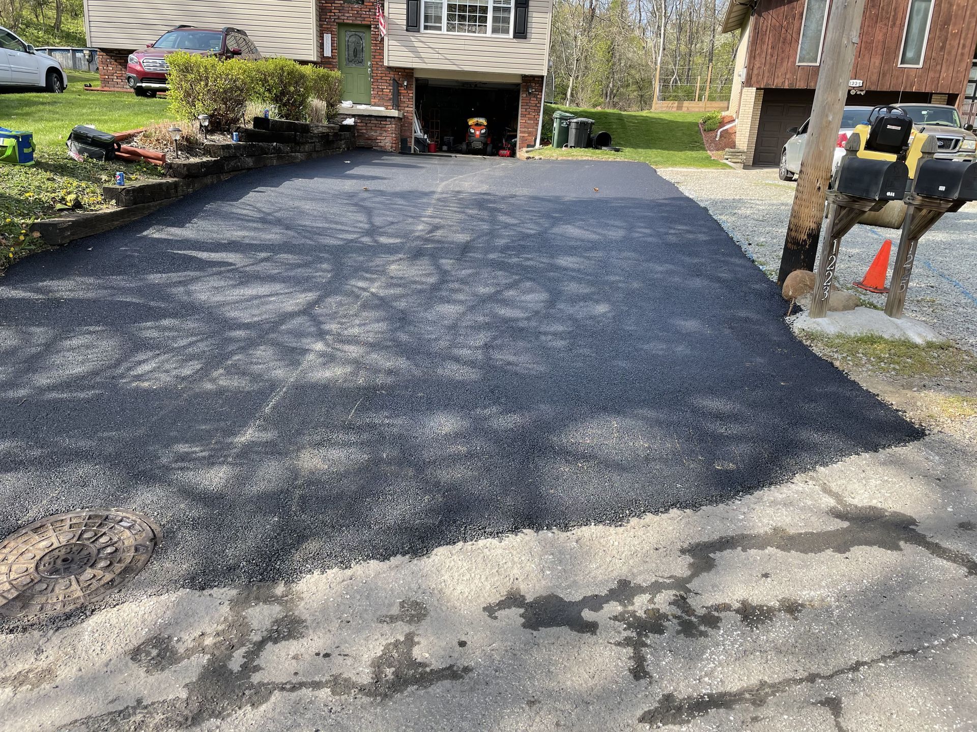 Newly paved asphalt driveway in front of a house.