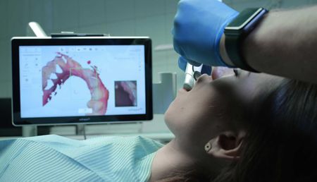 A woman is getting her teeth examined by a dentist.