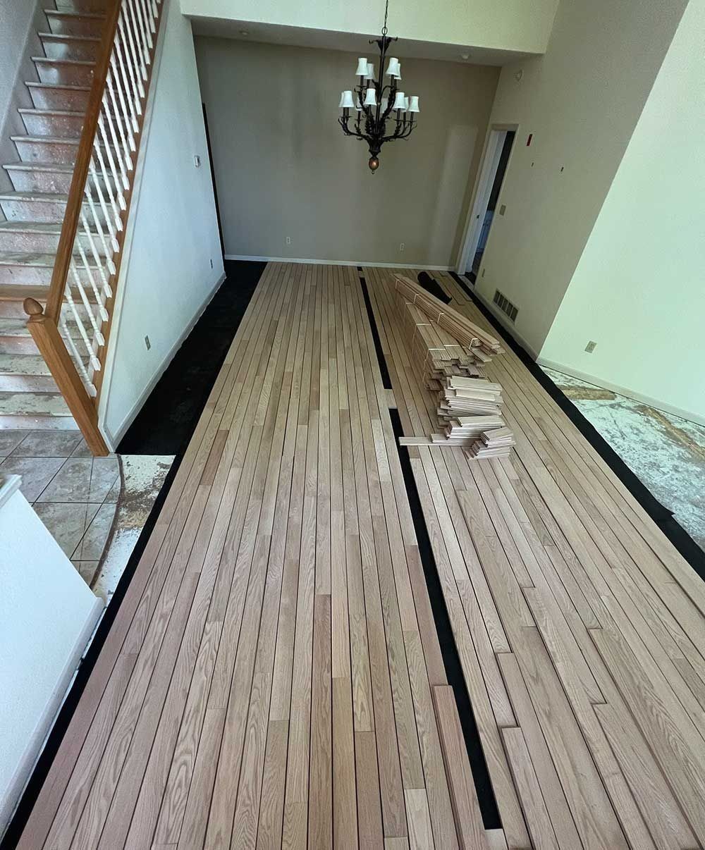 A long wooden hallway with a chandelier hanging from the ceiling.