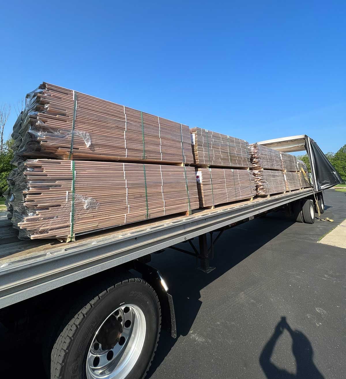 A truck with a stack of wood on the back of it