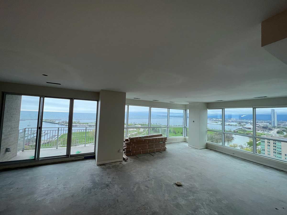A large empty room with a lot of windows and a view of the ocean.